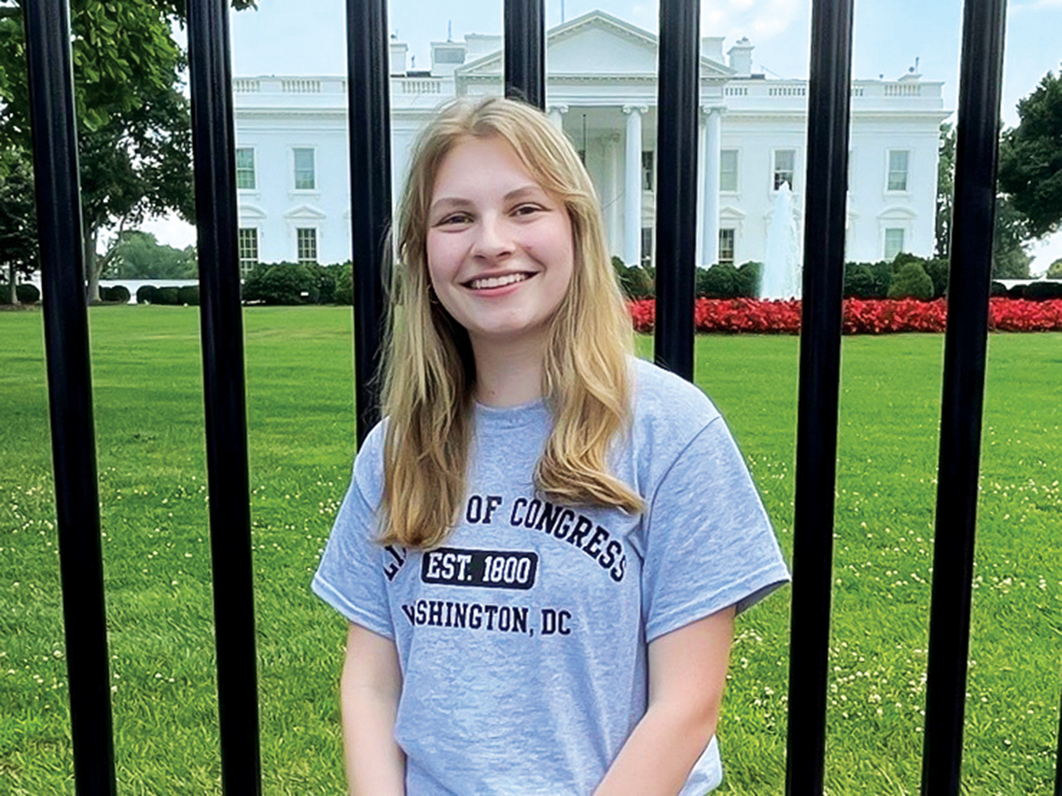 student in front of white house